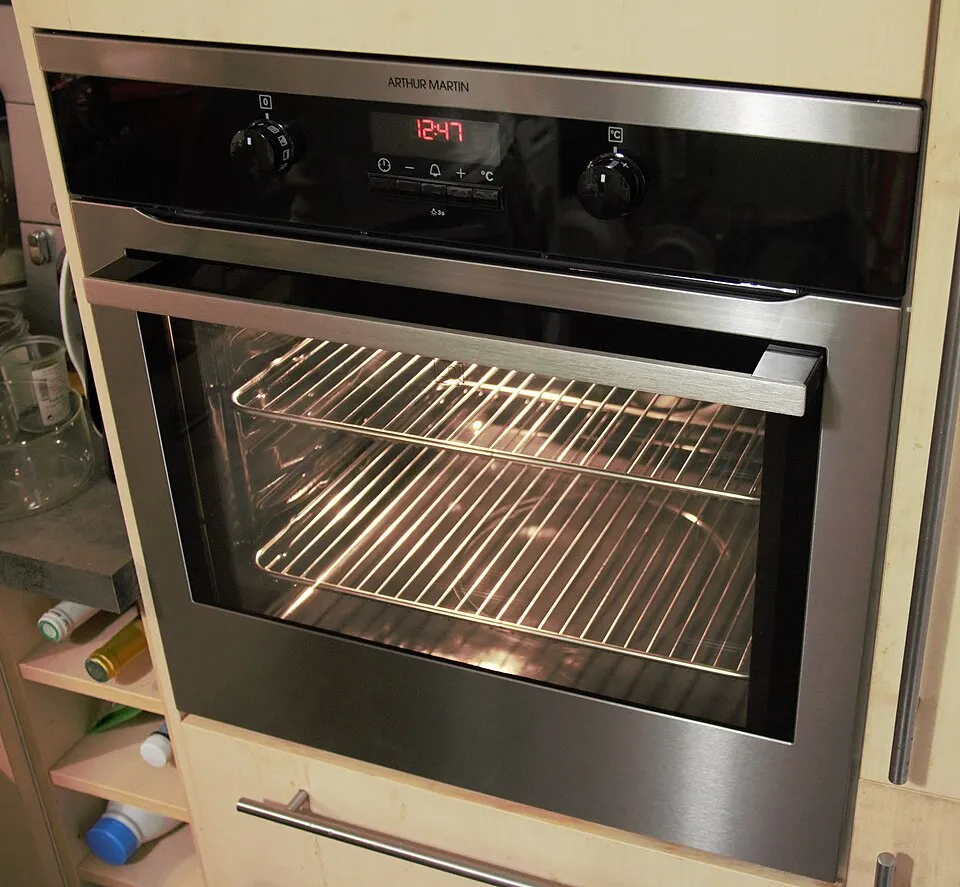 Built in self cleaning oven with a lit interior, racks and a digital clock on the control panel